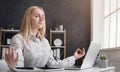 Businesswoman relaxing and meditating at workplace