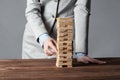 Businesswoman removing wooden block from tower