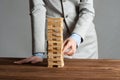 Businesswoman removing wooden block from tower