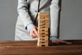 Businesswoman removing wooden block from tower