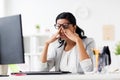 Businesswoman rubbing tired eyes at office