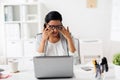 Businesswoman rubbing tired eyes at office