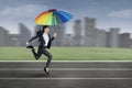 Businesswoman running with colorful umbrella