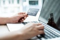 The businesswoman`s hand is holding a credit card and using a laptop for online shopping and internet payment in the office