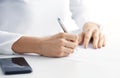 Businesswoman`s hand holding pen and writing something Royalty Free Stock Photo