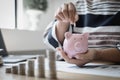 Businesswoman`s hand holds money or coins into a piggy bank, Managing money or saving money for future use Royalty Free Stock Photo