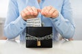 Businesswoman saving banknote in wallet with lock
