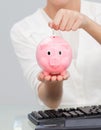 Businesswoman saving money in a piggibank Royalty Free Stock Photo