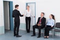 Businesswoman Shaking Hands With Man In Front Of People Royalty Free Stock Photo