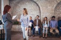 Businesswoman shaking hands with woman besides people waiting for job interview Royalty Free Stock Photo