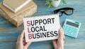 Businesswoman Showing Card with support local business message