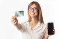 Businesswoman Showing Credit Card And Phone Standing, Studio Shot Royalty Free Stock Photo