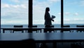 Businesswoman silhouette walking window in office conference room at sea view.