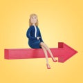 The businesswoman sits on the arrow and shows the right direction. Royalty Free Stock Photo