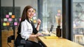 A businesswoman sits in a coffee shop with her portable laptop Royalty Free Stock Photo