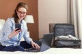 Businesswoman working in hotel room, using laptop and mobile phone Royalty Free Stock Photo