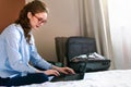 Businesswoman working in hotel room, using laptop and mobile phone Royalty Free Stock Photo