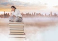 Businesswoman sitting on Books stacked by distant city Royalty Free Stock Photo