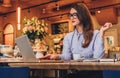 Businesswoman is sitting in cafe at table, working on laptop. Hipster girl blogging, browsing internet, checking email.