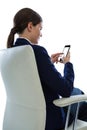 Businesswoman sitting on chair and using mobile phone Royalty Free Stock Photo