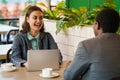 Businesswoman sitting in coffee shop together with businessman having business talking Royalty Free Stock Photo