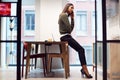 Businesswoman Sitting On Desk In Meeting Room Talking On Mobile Phone Royalty Free Stock Photo