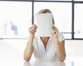 Businesswoman Sitting At Desk In Office With Face Hidden Behind