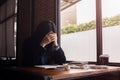 Businesswoman sitting with head in hands at desk and crumpled papers Royalty Free Stock Photo