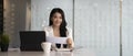 Businesswoman sitting at her office desk smiling to camera and holding envelope. Royalty Free Stock Photo