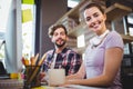 Businesswoman sitting by male coworker at computer desk