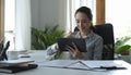 Businesswoman sitting in modern office and checking financial data on digital tablet Royalty Free Stock Photo