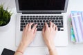 Businesswoman sitting at office desk and typing on a laptop hands close up. View from above. Royalty Free Stock Photo