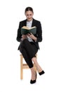 Businesswoman sitting and reading her book fascinated