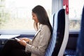 Businesswoman Sitting In Train Commuting To Work Checking Messages On Mobile Phone Royalty Free Stock Photo