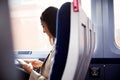 Businesswoman Sitting In Train Commuting To Work Checking Messages On Mobile Phone Royalty Free Stock Photo