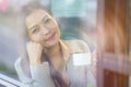 Businesswoman sitting by window in coffee shop holding coffee cup Royalty Free Stock Photo