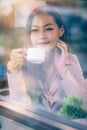 Businesswoman sitting by window in coffee shop holding coffee cup Royalty Free Stock Photo