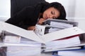 Businesswoman sleeping on piles of folders