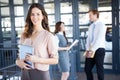 Businesswoman smiling at camera while her colleagues discussing in background Royalty Free Stock Photo