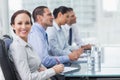 Businesswoman smiling at camera while her colleagues listening t Royalty Free Stock Photo