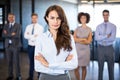 Businesswoman smiling at camera while her colleagues standing in background Royalty Free Stock Photo