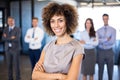Businesswoman smiling at camera while her colleagues standing in background Royalty Free Stock Photo
