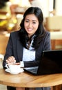 Businesswoman smiling while stirring a coffee