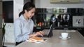 Businesswoman working online with computer  tablet at home kitchen counter. Royalty Free Stock Photo