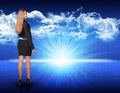 Businesswoman standing against blue landscape with Royalty Free Stock Photo