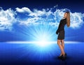 Businesswoman standing against blue landscape with Royalty Free Stock Photo