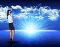 Businesswoman standing against blue landscape with Royalty Free Stock Photo