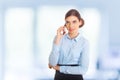 Businesswoman standing against office window talking on mobile phone Royalty Free Stock Photo