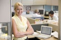 Businesswoman standing in cubicle smiling