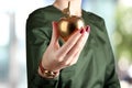 Businesswoman standing and holding golden apple in her hand. Royalty Free Stock Photo